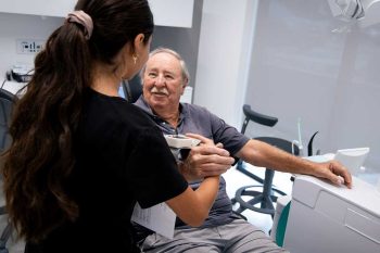 Millcreek Family Dental team member talking to an older patient