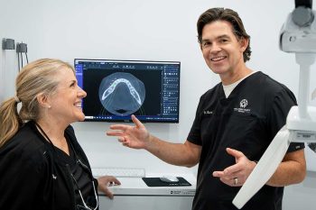 Dr. Baird explaining a process while showing dental x-rays